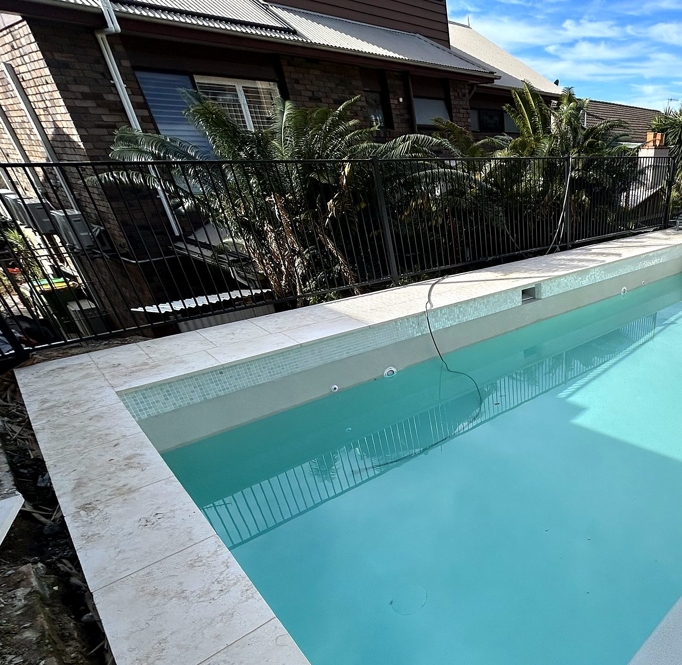 Finished pool with light interior and travertine surrounds