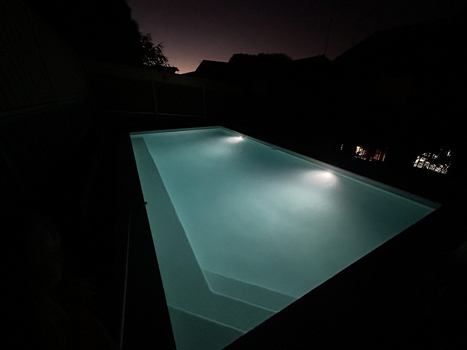 Freshly finished pool glowing under its lights at night